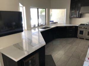 Kitchen with large white quartz island and black base cabinetry
