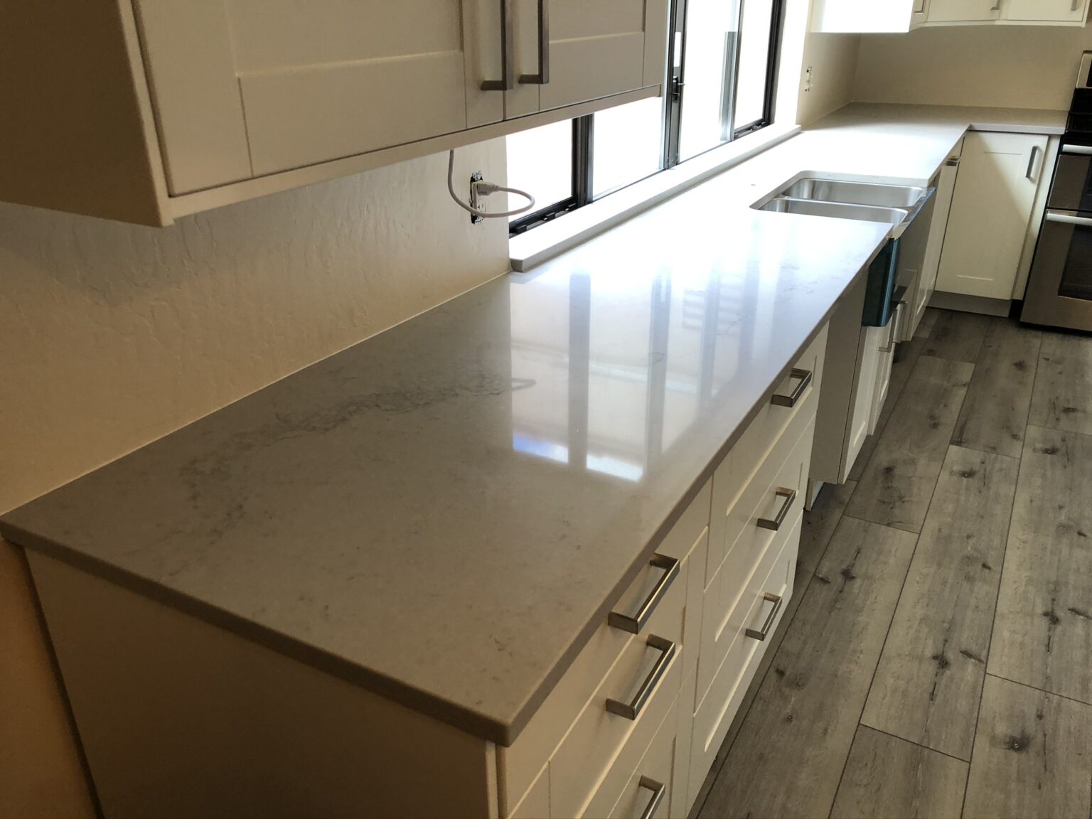 Galley kitchen with cream cabinetry and quartz countertop